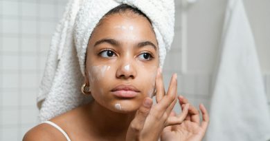 Personne appliquant une crème sur son visage dans la salle de bain.