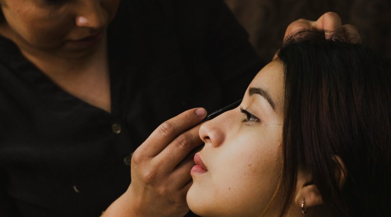 Maquilleuse en train de maquiller une cliente, exemple de pratique en esthétique.