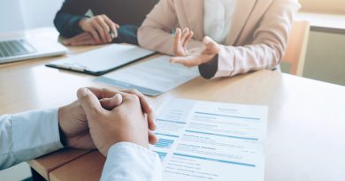 Trois personnes en entretien professionnel, avec un CV posé sur la table.