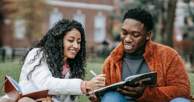 Deux étudiants assis dehors, discutant et étudiant ensemble, représentant l’orientation scolaire et les opportunités pour les jeunes.