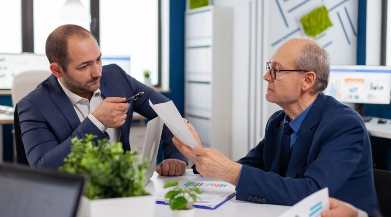 Un conseiller patrimonial échange avec un client dans un bureau moderne