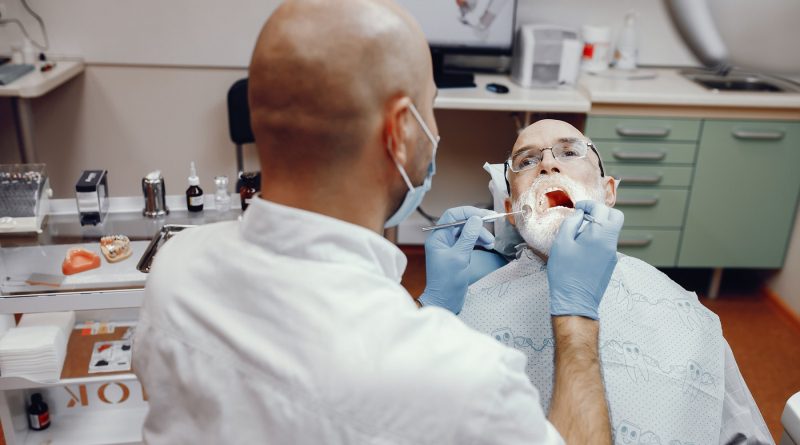 Vieil homme assis dans le bureau du dentiste