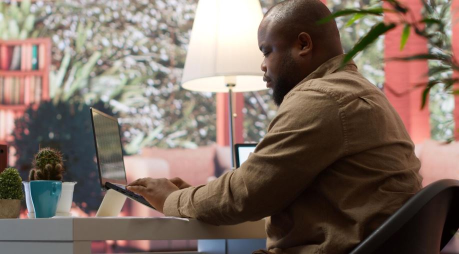 Un homme africain utilisant un ordinateur portable
