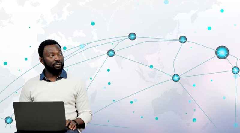 Homme avec un ordinateur portable devant une carte du monde avec des connexions en réseau