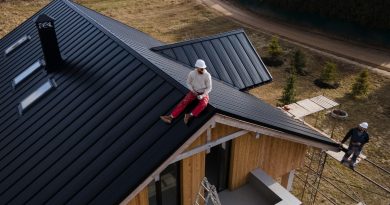 homme avec casque assis sur le toit d'une maison