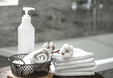 Serviettes blanches, coton et flacon distributeur pour un confort discret dans la salle de bain.