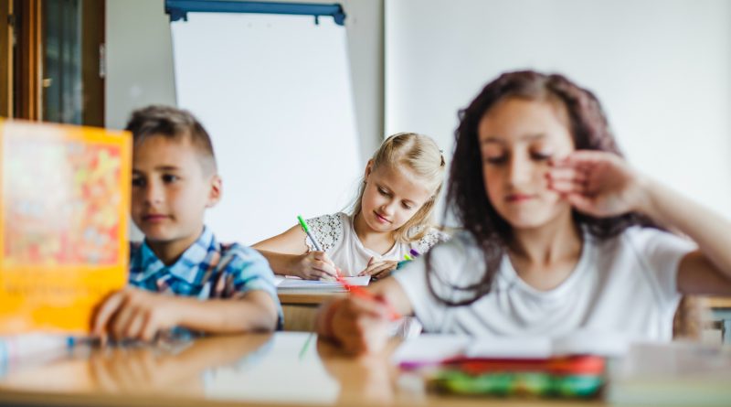 trois enfants étudiant en classe