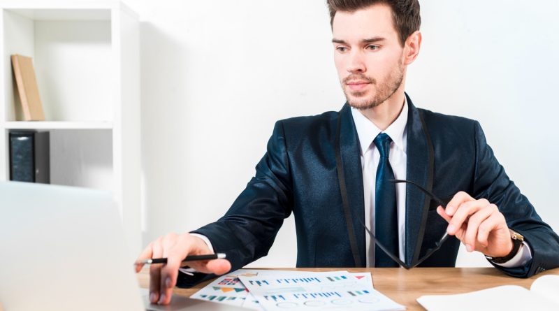 Jeune expert financier analysant des rapports sur ordinateur pour sécuriser des investissements