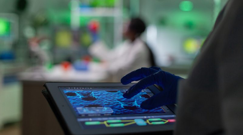 Analyse de données microscopiques sur tablette dans un laboratoire scientifique moderne.