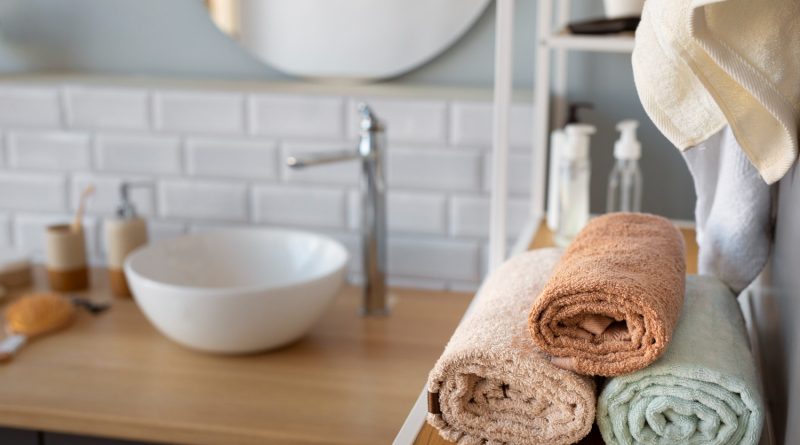 des serviettes de toilette moelleuses et soigneusement roulées sur une étagère en bois