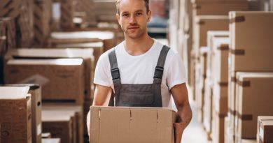 Opérateur portant un colis dans un entrepôt e-commerce.