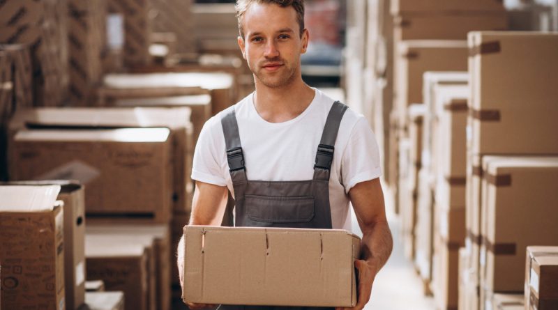 Opérateur portant un colis dans un entrepôt e-commerce.