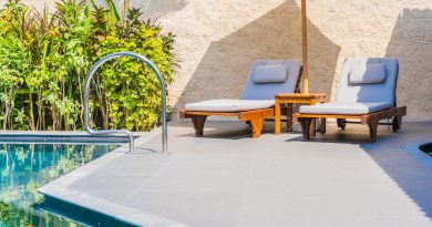 Espace détente avec chaises longues et parasol sur une terrasse moderne au bord d'une piscine.