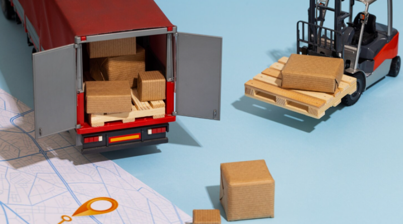 Next Terra International : un partenaire stratégique pour la logistique internationale Maquette miniature d'un camion de transport, d'un chariot élévateur avec des colis en carton et d'une carte routière sur fond bleu