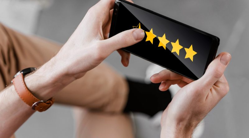 Daniel Moquet : quand les avis clients deviennent un levier d’amélioration continue ? une personne tenant un smartphone à deux mains en mode paysage pour attribuer une note sous forme d'étoiles