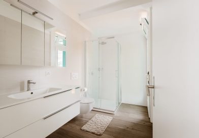 Tapis de bain La Berge : avis, confort et qualité, que pensent réellement les utilisateurs ? une salle de bain moderne et lumineuse dotée d'un meuble vasque blanc, de toilettes suspendues, d'une cabine de douche vitrée et d'un parquet effet bois.