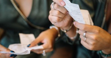 deux personnes observant et comparant des tickets de jeu ou reçus de loto qu'elles tiennent entre leurs mains