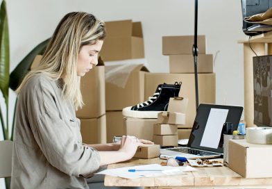 Enfin Libre avis : comment évaluer sérieusement un accompagnement e-commerce en 2026 ? Une femme préparant des colis et gérant des commandes devant son ordinateur portable dans un atelier d'e-commerce