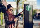Une femme réglant son stationnement à un horodateur tout en tenant son téléphone.