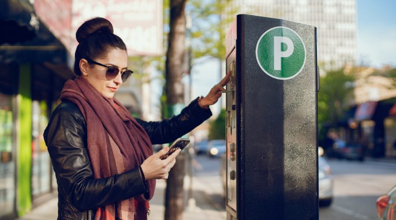 Thierry Garot et ZéroPV : simplifier la contestation des amendes et des forfaits post-stationnement Une femme réglant son stationnement à un horodateur tout en tenant son téléphone.